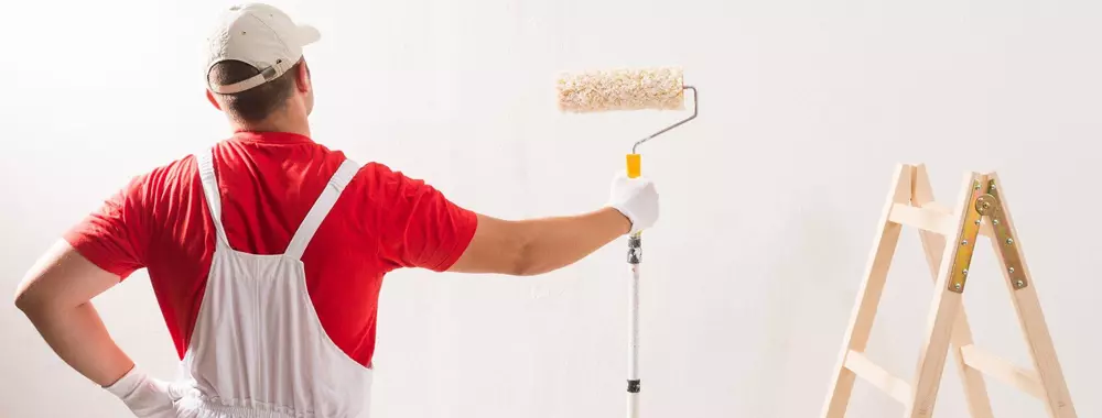 Skilled painter transforming a room with FixitDubais professional painting services